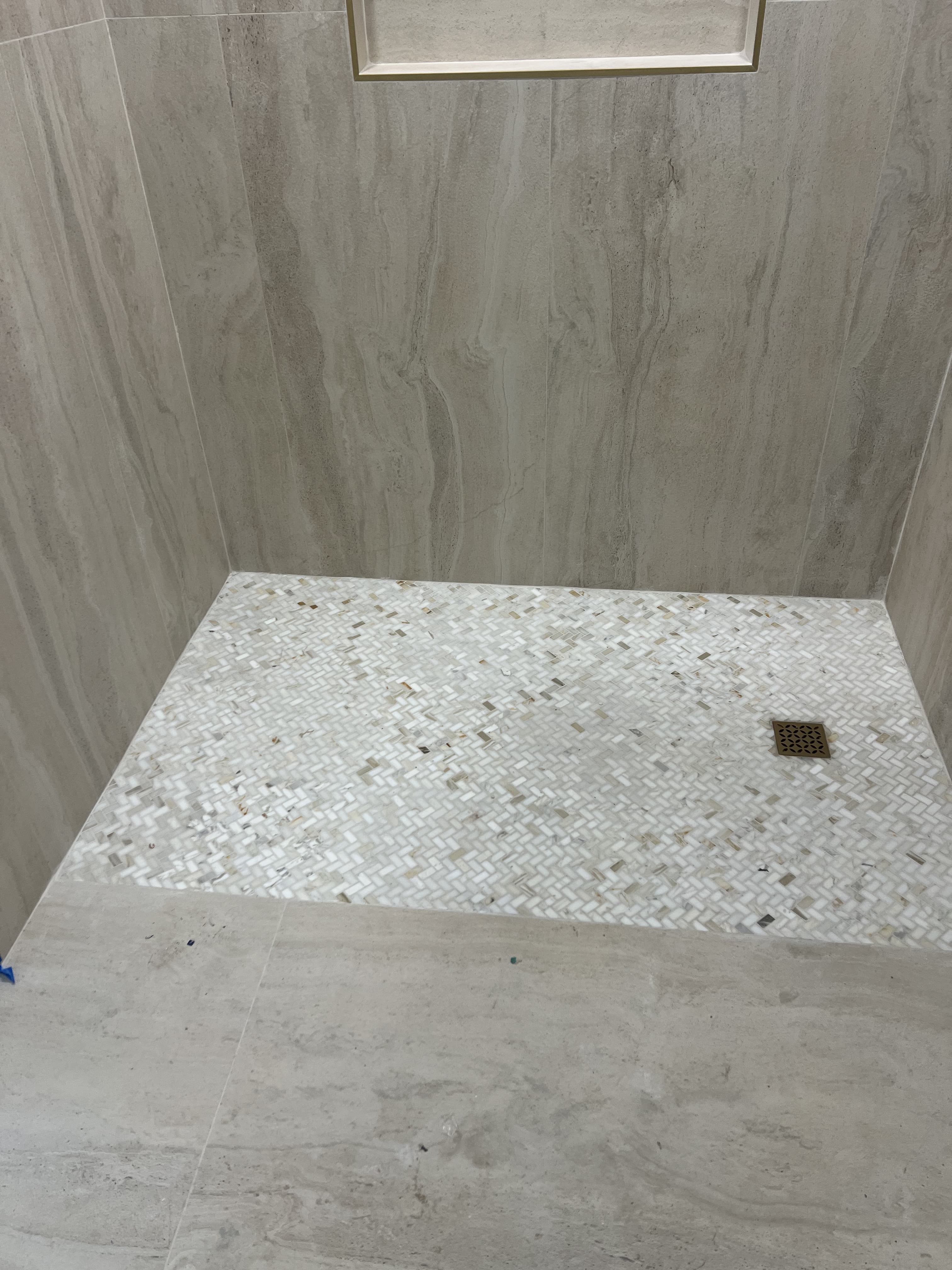 Shower floor with herringbone mosaic tile